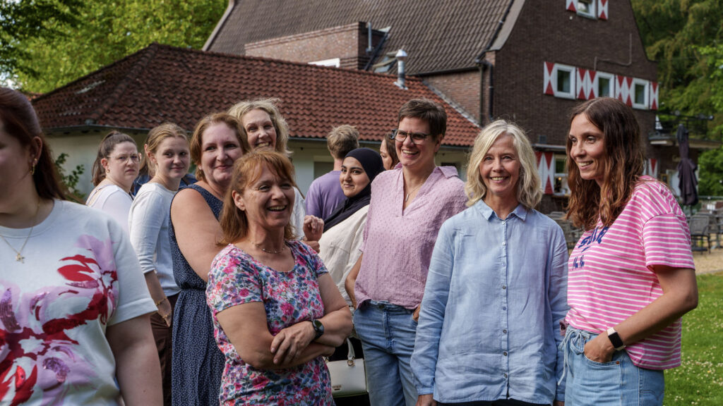 Einige aus dem Praxisteam beim letzten Sommerfest 2026 schauen direkt in die Kamara