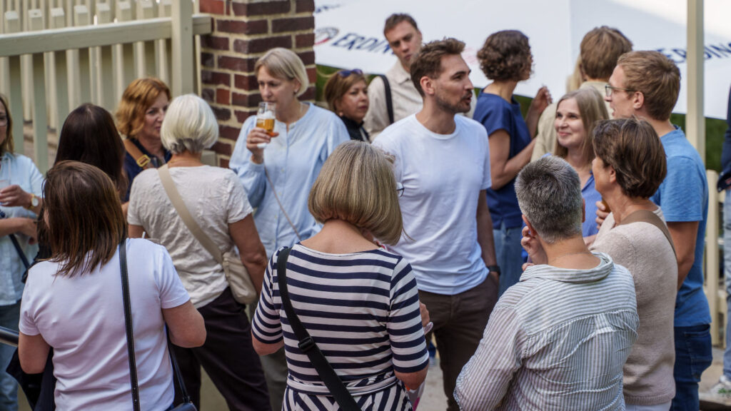 Einige aus dem Praxisteam stehen auf der Terasse der Gaststätte im lockeren Gespräch beim letzten Sommerfest 2026