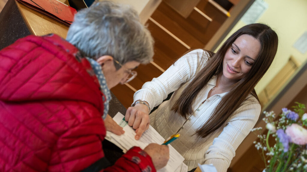 Mitarbeitende am Empfang der Onkologie Münster im Gespräch mit einer Patientin